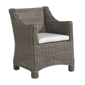 A stylish outdoor dining chair in a classic wicker style weave. Has a off-white seat cushion and arms. Looks like a very comfortable dining chair.